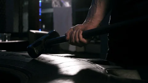 Strong man in training with a hammer and wheel Stock Footage 88931385