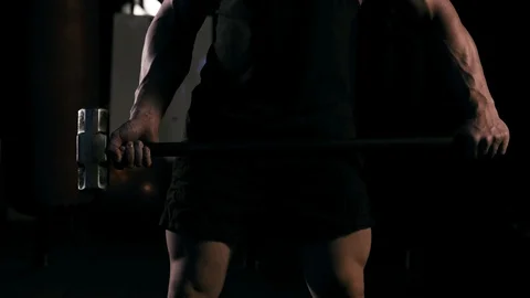Strong man in training with a hammer and wheel Stock Footage 89604676