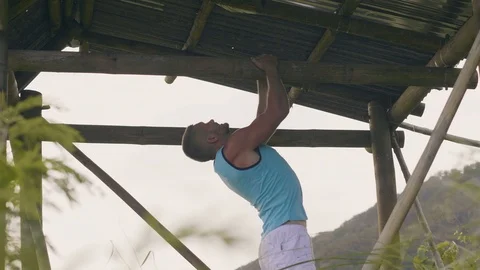 Strong man training pull ups on wooden crossbar while workout outdoor. Fitness Video stock 107140447