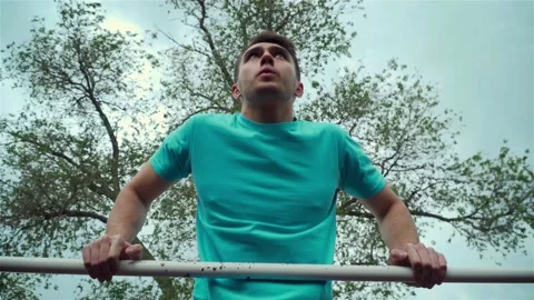 Strong man training pull ups exercise enjoying intense fitness workout outdoors Stock Footage 132821202