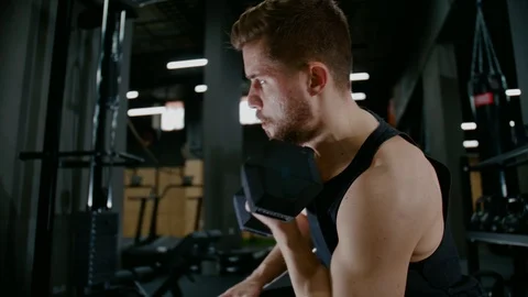 A strong Man Tries to Pump up his Arms , a Man Works out with a Dumbbell, a Guy Stock Footage 127240785