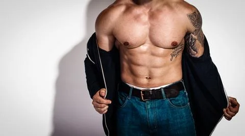 Strong man undressing Stock Photos