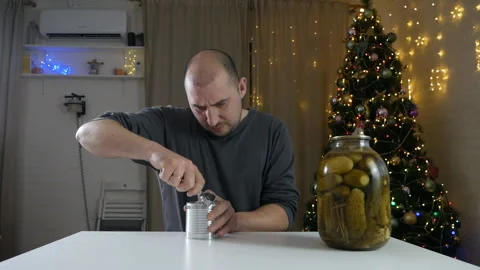 Strong man using opener hands cutting the lid of a metal can on a table with Stock Footage 146289909