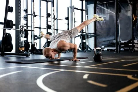 Strong man walking on hand during crossfit training in fitness club. Stock Photos
