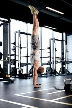 Strong man walking on hand during crossfit training in fitness club. Stock Photos
