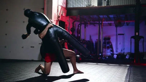 Strong man warming up. Boxing on mats and throws punches by his hands fists on Stock Footage 155622532