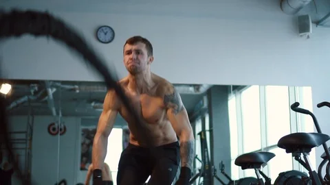 Strong man working out with Battle Ropes in gym Stock Footage 100712913
