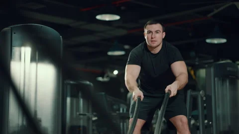 Strong man working out with battle ropes in gym Stock Footage 148326201