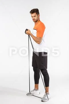 Strong masculine handsome sportsman in football activewear, standing full-length Stock Photos