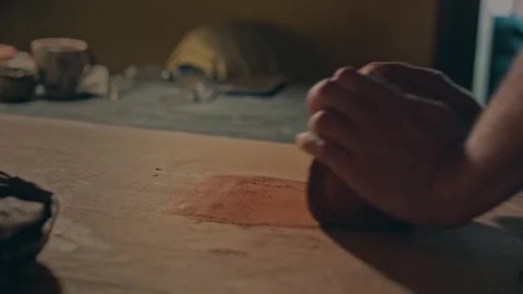 Strong master hands knead the tight clay for work on pottery spinning wheel Stock Footage 257671526