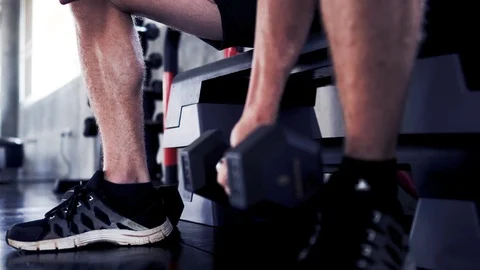 Strong men exercise by lifting weight pendulums or dumbbells in the gym Stock Footage 109124593
