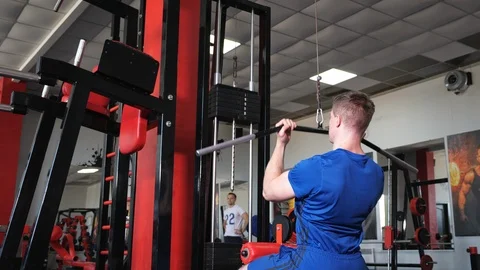 Strong muscular man using pulldown cable machine Stock Footage 119174805