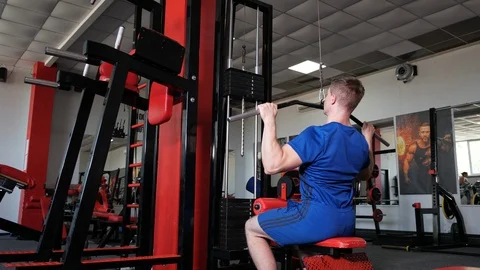 Strong muscular man using pulldown cable machine Stock Footage 119174996