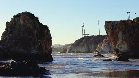 Strong ocean wave hitting the rocky cliffs in sunset time at Pismo Beach Stock Footage 261919785