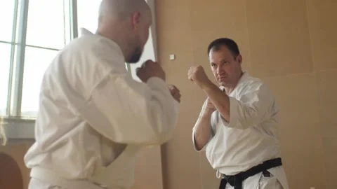 Strong oldman falling and gets up after taking kick from bold bearded newbie Stock Footage 137266891