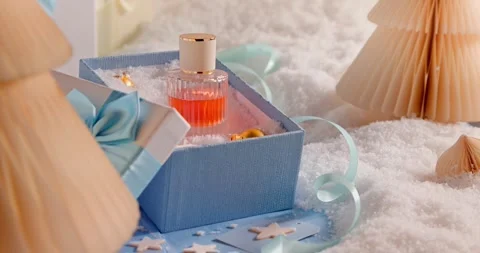 Strong perfume sits inside a lovely Christmas gift box. Vídeo Stock 346060663