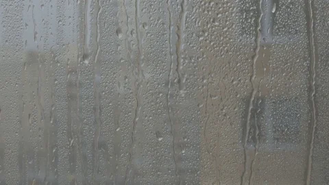 Strong rain falling n pane of glass, drops of rain coming down, grey sky with Stock Footage 74218823