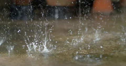 Strong rainfall splashing on the ground, creating scattered droplets. Stock Footage 316487149