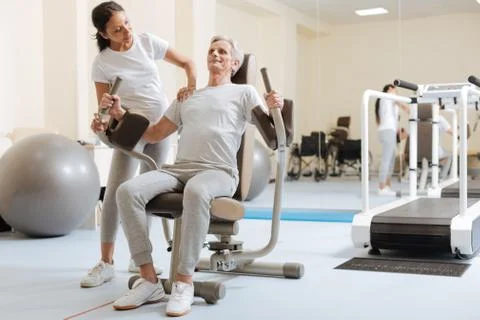 Strong retirement sitting on the training device 스톡 사진