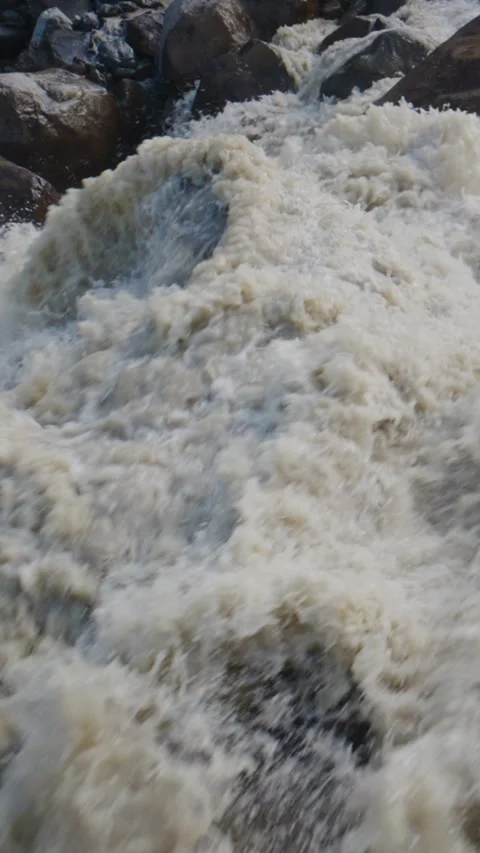 Strong river current churns violently near rocky shore Stock Footage 335570950