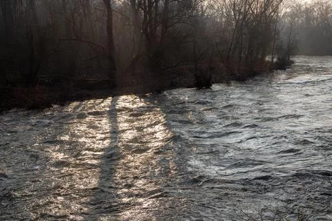 Strong river current with lots of rocks and shrubs in winter Stock Photos