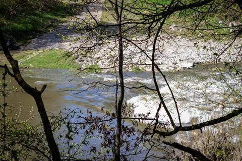 Strong river current, splash of water, waves and large stones. 库存照片