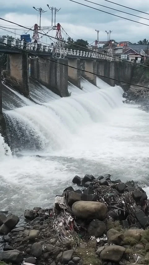 Strong river currents rush over a low katulampa concrete dam Stock Footage 328465588