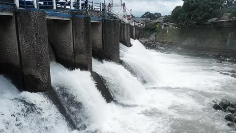 Strong river currents rush over a low katulampa concrete dam Stock Footage 328465595