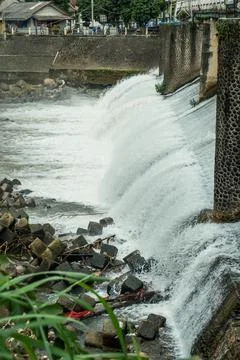 Strong river currents rush over a low katulampa concrete dam Stock Photos