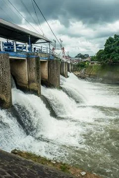 Strong river currents rush over a low katulampa concrete dam Stock Photos