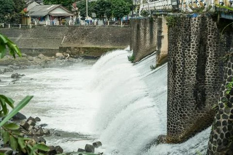 Strong river currents rush over a low katulampa concrete dam 库存照片