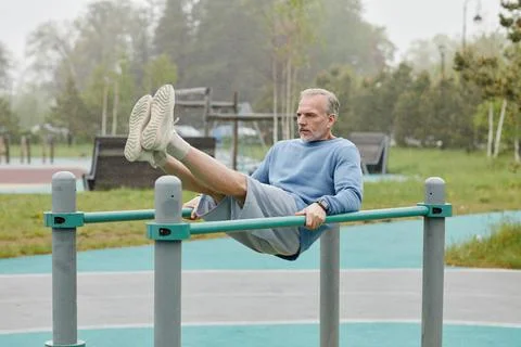 Strong Senior Man On Parallel Bars Outdoors Stock Photos