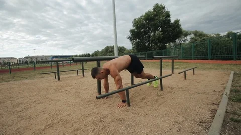 Strong shirtless man doing push-ups and jumping up on the street sports ground 库存影片 121901647