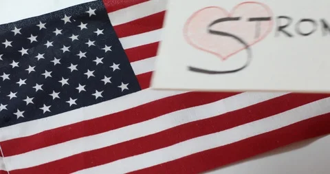 Strong sing being laid on an American flag small USA pride flag placed on sign Stock Footage 128775225
