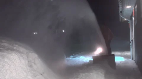Strong snow blowing hiding man cleaning snow with snow blower machine Stock Footage 231370296