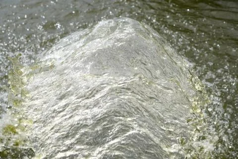 A strong stream of water from the pipe flows into the river, air bubbles in t Foto stock