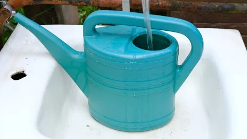 A strong stream of water pours into the garden watering can. Stock Footage 155273914