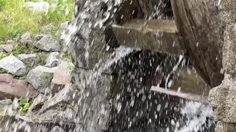 A strong stream of water scatters in different directions from the water mill Stock Footage 241210084