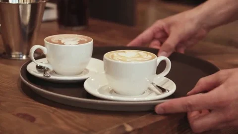A strong waiter's hand carries a brown tray with coffee espresso Stock Footage 69083752