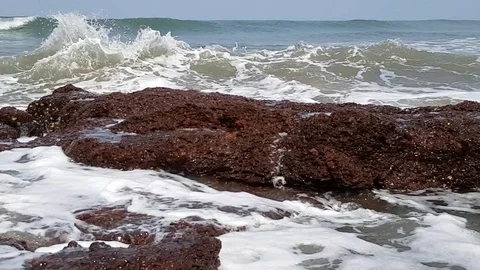 Strong waves break against big rocks on the shore. Stock Footage 117974339