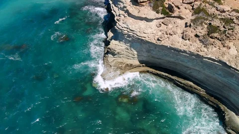 Strong waves break on rocky seashore on sunny day, view from above Stock Footage 107277596
