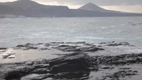 Strong waves breaking on black rocks at the beach of Gran Canaria Stock Footage 128736098