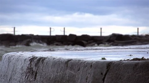 Strong waves crash up against a cement retaining wall in super slow motion Stock Footage 93782800