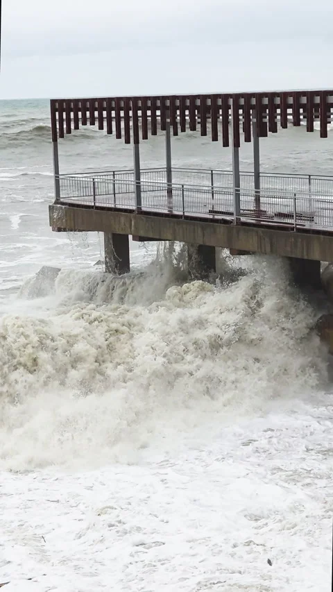 Strong waves hit harbor structure. Harbor pier enduring fierce storm surge Vidéo 331432907