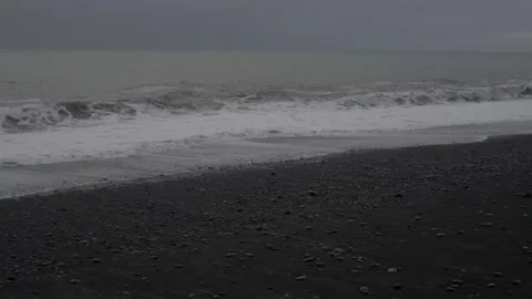 Strong waves roll onto the black beach Stock Footage 130461573