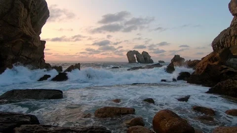 Strong waves surge through a narrow rocky coastal inlet during dus.. Stock Footage 343227493