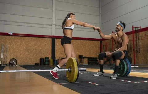 Strong weightlifters bumping fists during workout Stock Photos