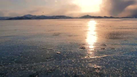 Strong wind is blowing the snow crystals over the frozen iced surface of lake Video stock 153758609