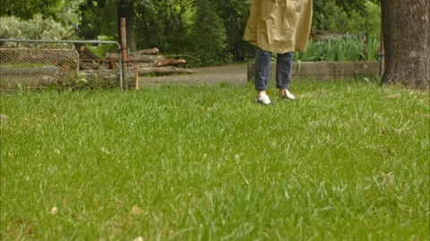 Strong wind blows on green grass, women's legs in the background Video stock 198693091