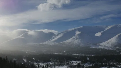 Strong wind blows on mountain peaks and white snowy clouds Video stock 108849950